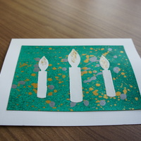 Candles on Green: white candles over a speckled green canvas.