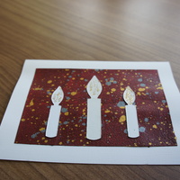 Candles on Red: white candles over a speckled red canvas.